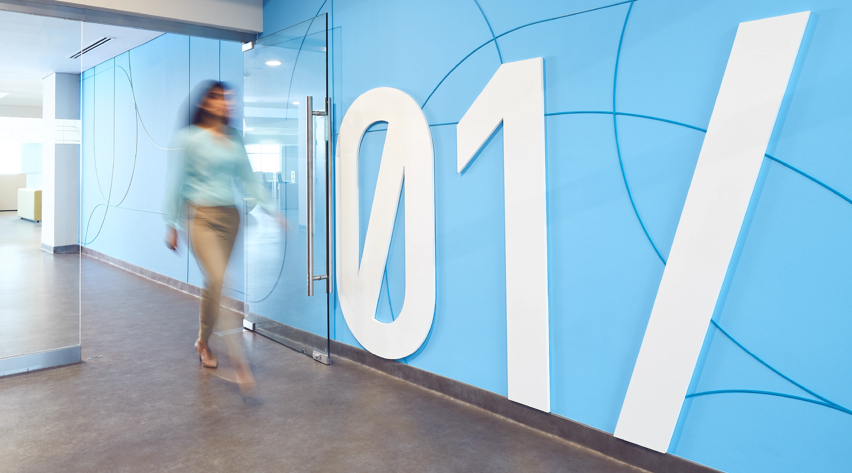 Brand environment wayfinding inside the Emirates Flight Training Academy — large-scale '01' typography on teal